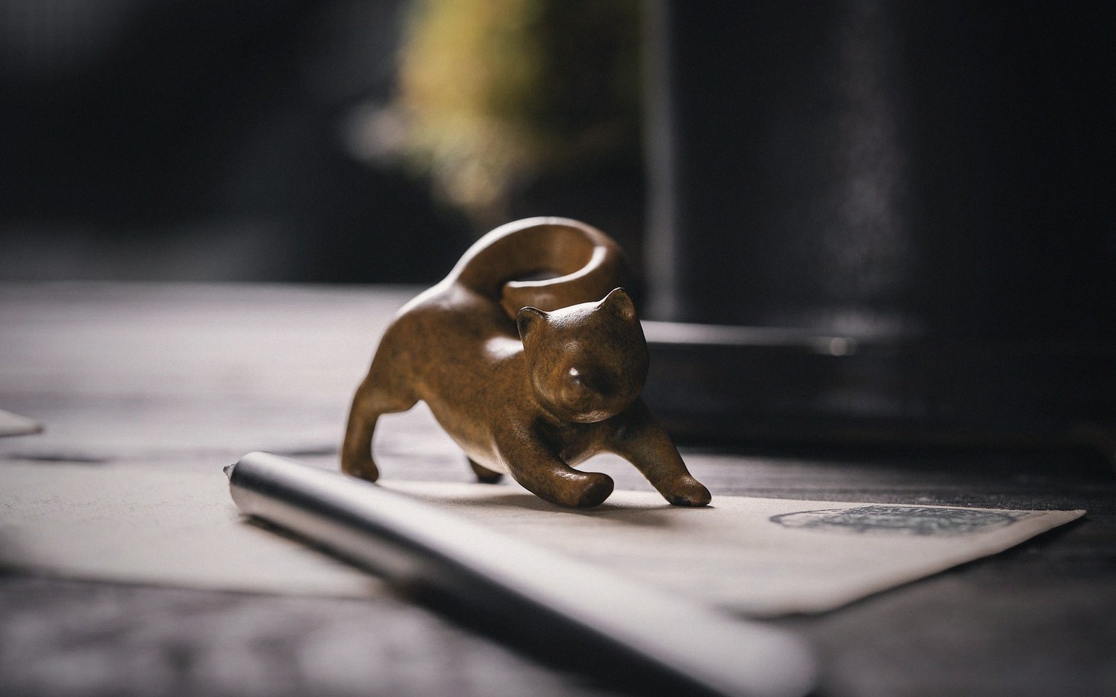 A small bronze animal maquette on a turntable, raking light on the modelling